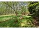 Large and well-manicured backyard with statues and landscaping near the home and wooden bridge at 6321 Malvern Ln, Hillsborough, NC 27278