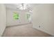 Neutral bedroom with carpet, two windows for natural light, ceiling fan, and white trim at 6321 Malvern Ln, Hillsborough, NC 27278