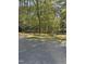 Wide driveway near a wooded lot with a small patch of grass and weeds at 6321 Malvern Ln, Hillsborough, NC 27278