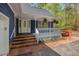 Inviting front porch with white railing, brick steps, and a painted blue exterior at 6321 Malvern Ln, Hillsborough, NC 27278