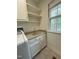 Laundry room featuring a sink, under cabinet storage, and open shelving for optimal organization at 6321 Malvern Ln, Hillsborough, NC 27278