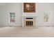 Spacious living room featuring a fireplace, large windows and neutral carpeting at 6321 Malvern Ln, Hillsborough, NC 27278