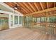 View of the wood-floored porch showing ceiling fans and access to a backyard patio with railing at 6321 Malvern Ln, Hillsborough, NC 27278