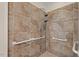 Walk-in shower featuring decorative tile surround, grab bars, and dual shower heads at 6321 Malvern Ln, Hillsborough, NC 27278
