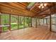 Bright sunroom featuring wood ceiling and walls of windows with view to trees and landscaping at 6321 Malvern Ln, Hillsborough, NC 27278