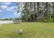 Large backyard surrounded by mature trees with a trampoline and playset at 65 Cattail Ln, Zebulon, NC 27597