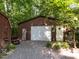 Detached garage and storage building, surrounded by lush greenery and a lawn mower at 6760 Keansburg Rd, Gibsonville, NC 27249