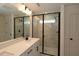 Bathroom with dual sink vanity, framed mirror, and walk-in shower with glass enclosure and black trim at 6973 Doddridge Ln # 17, Cary, NC 27519