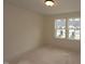 This bedroom features bright natural light from two windows and neutral walls at 6973 Doddridge Ln # 17, Cary, NC 27519