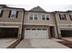 New two-story townhouse with neutral siding, stone accents, attached two-car garage and driveway at 6973 Doddridge Ln # 17, Cary, NC 27519