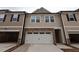 New two-story townhouse with neutral siding, stone accents, attached two-car garage and driveway at 6973 Doddridge Ln # 17, Cary, NC 27519