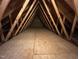 Spacious attic with wooden beams and plywood flooring at 7021 Oviedo Dr, Raleigh, NC 27603