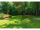 Expansive back yard featuring a deck and tree-lined perimeter offering privacy and a serene outdoor setting at 7021 Oviedo Dr, Raleigh, NC 27603