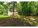 Large backyard with mature trees, lush greenery, and a wooden deck at 7021 Oviedo Dr, Raleigh, NC 27603