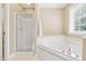 Bathroom features a walk-in shower and a soaking tub under a window at 7021 Oviedo Dr, Raleigh, NC 27603