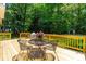 Wooden deck with a table and chairs, surrounded by lush greenery at 7021 Oviedo Dr, Raleigh, NC 27603