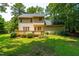 Back exterior view of a two-story home, featuring a wooden deck and lush landscaping at 7021 Oviedo Dr, Raleigh, NC 27603