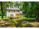 Back exterior view of a two-story home surrounded by lush greenery and mature trees at 7021 Oviedo Dr, Raleigh, NC 27603