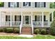 Charming front porch with classic white columns, brick steps, and a welcoming entrance at 7021 Oviedo Dr, Raleigh, NC 27603