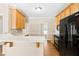 Kitchen view with breakfast bar, black appliances, and hardwood flooring at 7021 Oviedo Dr, Raleigh, NC 27603