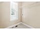 Compact laundry room with tile floor, window, utility sink and wire shelves at 7021 Oviedo Dr, Raleigh, NC 27603