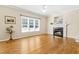 Bright living room features hardwood floors, large windows and cozy fireplace at 7021 Oviedo Dr, Raleigh, NC 27603