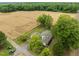 Aerial view showcases this home's setting among mature trees, adjacent to a field and convenient to a main road at 7042 Us 401 Highway N, Fuquay Varina, NC 27526