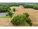 Breathtaking aerial view of property featuring large pond, fields, and mature trees at 7042 Us 401 Highway N, Fuquay Varina, NC 27526