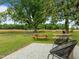 The backyard features mature trees, picnic tables, a play structure, and a comfortable seating area on a gravel base at 7042 Us 401 Highway N, Fuquay Varina, NC 27526