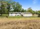 This backyard features mature trees, playset, picnic tables, and ample space for recreation and relaxation at 7042 Us 401 Highway N, Fuquay Varina, NC 27526