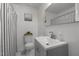 Clean and bright bathroom featuring white tiled walls, black and white striped shower curtain, and a gray vanity at 7042 Us 401 Highway N, Fuquay Varina, NC 27526