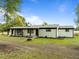 Home with painted brick, wood columns, rocking chairs, professional landscaping and attached garage at 7042 Us 401 Highway N, Fuquay Varina, NC 27526
