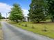 Long driveway leads to a charming home with mature trees in a lush, green yard at 7042 Us 401 Highway N, Fuquay Varina, NC 27526