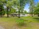 Aerial view of a painted brick home with mature trees and professionally landscaped yard at 7042 Us 401 Highway N, Fuquay Varina, NC 27526