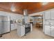 Bright, open kitchen with stainless steel appliances, island, and wood ceiling, flowing into the dining area at 7042 Us 401 Highway N, Fuquay Varina, NC 27526