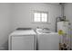 Bright laundry room features new front-load washer and dryer with efficient water heater at 7042 Us 401 Highway N, Fuquay Varina, NC 27526