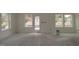 Living room with neutral walls, large windows, and a door leading to the backyard at 7106 Hubner Pl # 44, Cary, NC 27519