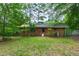 View of the backyard, highlighting the home's brick exterior and surrounding trees at 720 Sherrybrook Dr, Raleigh, NC 27610