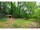 Secluded backyard featuring mature trees and an outbuilding, with plenty of foliage at 720 Sherrybrook Dr, Raleigh, NC 27610