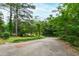 Long driveway on property surrounded by lush trees at 720 Sherrybrook Dr, Raleigh, NC 27610