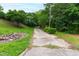 Long driveway leading up to property surrounded by lush trees and greenery at 720 Sherrybrook Dr, Raleigh, NC 27610