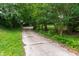 Long driveway lined with green trees and foliage, leading to the property at 720 Sherrybrook Dr, Raleigh, NC 27610