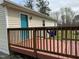 A stained wooden deck with a teal door, offering a relaxing outdoor space at 726 Thompson St, Pittsboro, NC 27312
