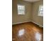 Bright bedroom showcasing original hardwood flooring and natural light from the windows at 726 Thompson St, Pittsboro, NC 27312