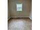 Cozy, empty bedroom with tile flooring, neutral paint, and a window letting in natural light at 726 Thompson St, Pittsboro, NC 27312