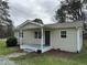 Charming single-story home featuring a covered porch, neutral siding, and well-maintained landscaping at 726 Thompson St, Pittsboro, NC 27312