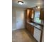 This kitchen offers warm cabinets, a double sink, tile floor, and a white dishwasher for modern convenience at 726 Thompson St, Pittsboro, NC 27312