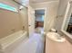 Bright bathroom with white hexagon tile flooring, pink vanity, and tub/shower combo at 8116 Reynard Rd, Chapel Hill, NC 27516