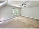 Large bedroom with plush neutral carpeting, ceiling fan, and large picture window at 8116 Reynard Rd, Chapel Hill, NC 27516