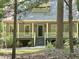 Charming home with a welcoming porch, beautiful columns and railings, set among mature trees at 8116 Reynard Rd, Chapel Hill, NC 27516